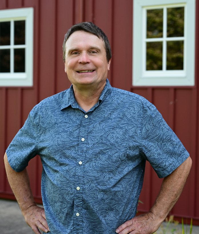 Mark Divitt standing outside a red barn in District 91